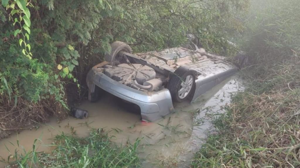 Motorista é resgatado após capotar e ficar submerso em corpo d”água