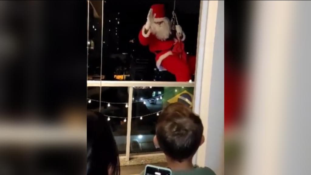 Bom velhinho chega de rapel e alegra o coração das crianças em edifício