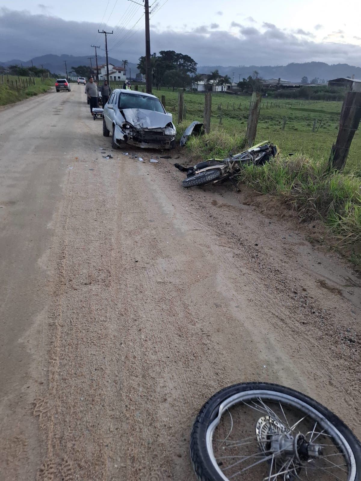 Motociclista é arremessado sobre carro e cai sob cerca após colisão frontal