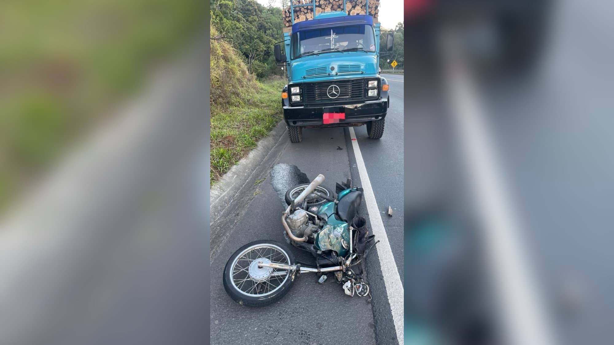 Motociclista de 27 anos morre após colisão com caminhão carregado de madeira