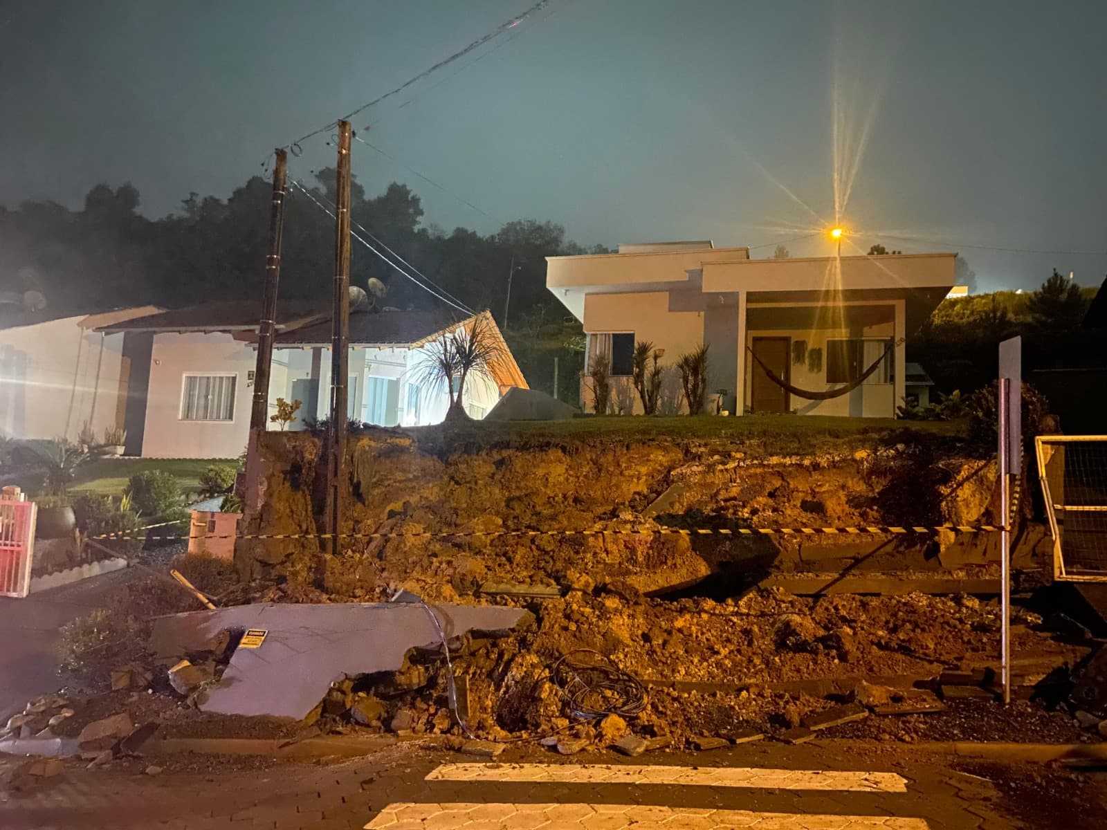 Muro desaba com temporal, atinge poste de energia e deixa moradores em risco em cidade de SC