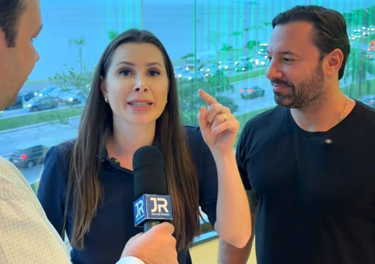 Deputada federal Caroline de Toni fala ao microfone do Jornal Razao ao lado do deputado Daniel Freitas durante encontro em Florianopolis