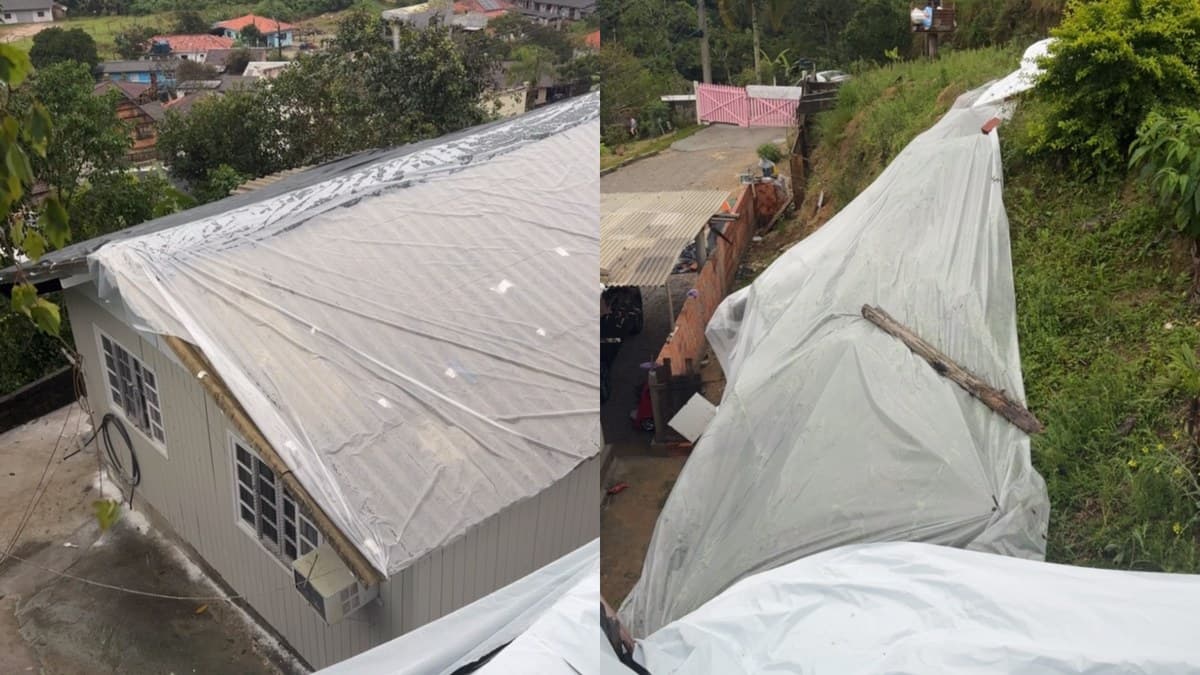 Casas em encosta com telhados cobertos por lonas depois do temporal em Santa Catarina